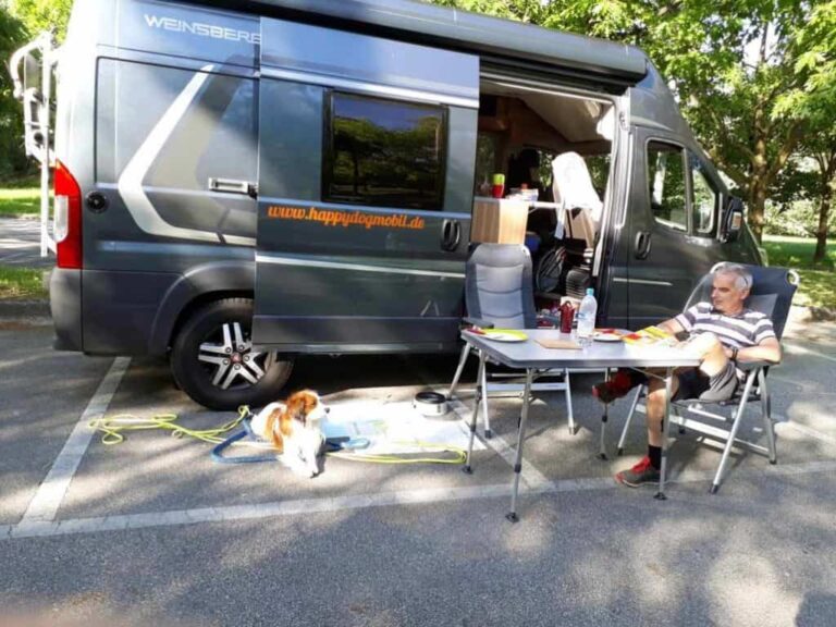 Frühstück vor dem Wohnmobil, der Hund Fiero schaut sein Herrchen an