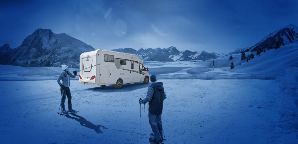 Wanderer im Schnee vor einem Knaus Wohnmobil